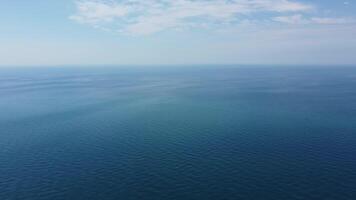 Aerial view from above on calm azure sea and volcanic rocky shores. Small waves on water surface in motion blur. Nature summer ocean sea beach background. Nobody. Holiday, vacation and travel concept video