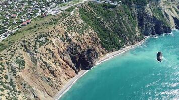 antenne visie van bovenstaand Aan kalmte azuur zee en vulkanisch rotsachtig oevers. klein golven Aan water oppervlakte in beweging vervagen. natuur zomer oceaan zee strand achtergrond. niemand. vakantie, vakantie en reizen concept video