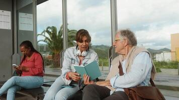 Tres personas sentado en un banco leyendo libros video