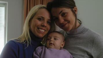 två kvinnor innehav en bebis och leende video