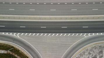 Top down aerial view of new highway high speed road intersections with few vehicles moving in the morning. video