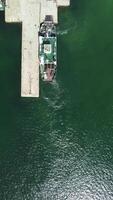 Ferry carrying cars and passengers across the sea, top down aerial drone view. Aerial vertical view on Ferry on the lake, transporting cars. deck of a boat carrying vehicles. video