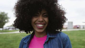 uma mulher com encaracolado cabelo sorrisos às a Câmera video