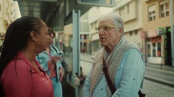 an older man and woman talking on a street video