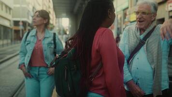 a senior man and two women are smiling while standing on a street video