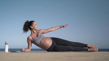 grávida mulher fazendo ioga em a de praia video