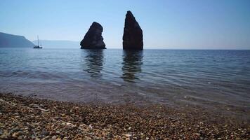 calma azzurro mare e vulcanico roccioso sponde. piccolo onde su acqua superficie nel movimento sfocatura. natura estate oceano mare spiaggia sfondo. nessuno. vacanza, vacanza e viaggio concetto video