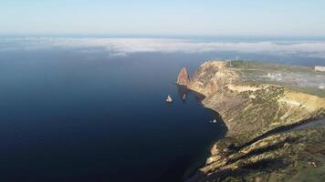 Aerial view from above on calm azure sea and volcanic rocky shores. Small waves on water surface in motion blur. Nature summer ocean sea beach background. Nobody. Holiday, vacation and travel concept video