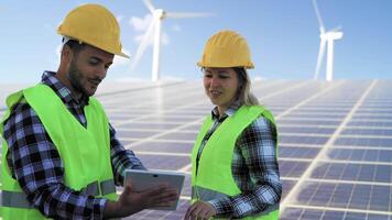 joven ingeniero trabajando para alternativa energía con viento turbina y solar panel - innovación y verde poder concepto video