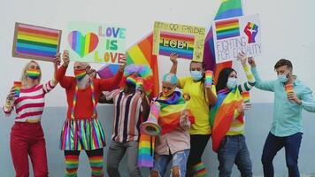 Lycklig raser människor bär ansikte mask fira på Gay stolthet festival under korona virus - grupp av vänner med annorlunda ålder och lopp dans tillsammans och stridande för kön jämlikhet video