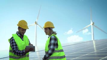 jong ingenieur aan het kijken Aan digitaal tablet de nieuw groen plan voor alternatief energie met wind turbine en zonne- paneel - innovatie en groen macht concept video