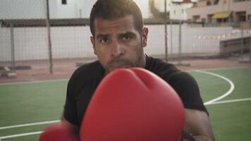 a man in a black shirt and red boxing gloves video