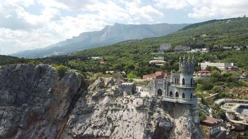 crimea svalans bo slott på de sten över de svart hav. den är en turist attraktion av krim. Fantastisk antenn se av de crimea kust med de slott ovan avgrund på solig dag. video