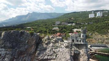 crimea svalans bo slott på de sten över de svart hav. den är en turist attraktion av krim. Fantastisk antenn se av de crimea kust med de slott ovan avgrund på solig dag. video