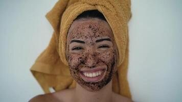 a woman using a facial mud mask video