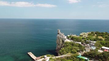 Crimea Swallow's Nest Castle on the rock over the Black Sea. It is a tourist attraction of Crimea. Amazing aerial view of the Crimea coast with the castle above abyss on sunny day. video