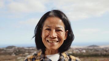 un asiático mujer sonriente en frente de el Oceano video