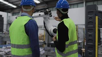 twee mannen in veiligheid vesten en moeilijk hoeden staand in voorkant van een robot video