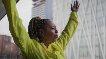 a woman in a yellow shirt raising her arms video