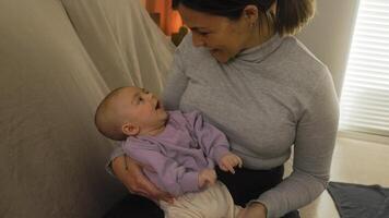 un mujer participación un bebé y sonriente video