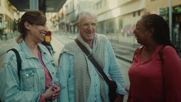 two women and an older man talking on a street video