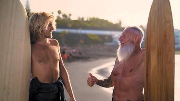 dois homens com barbas em pé Próximo para pranchas de surf video