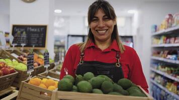 a woman holding a box of fruit in a supermarket video
