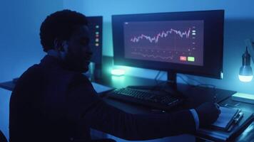 a man sitting at a desk with three monitors video