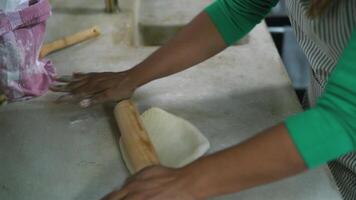 a woman is rolling out dough on a counter video