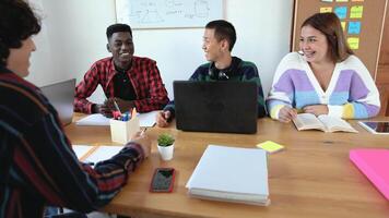 un grupo de joven personas sentado alrededor un mesa video