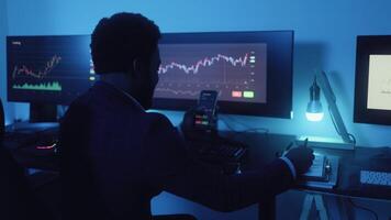 a man sitting at a desk with three monitors video