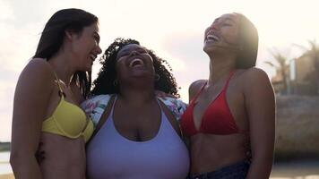 three women in bikinis laughing on the beach video