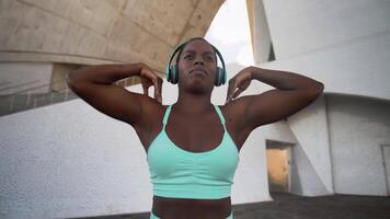 un mujer en un Deportes sostén parte superior y auriculares video