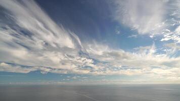 lasso di tempo multistrato cirro e cumulo nuvole in movimento nel luminosa tramonto cielo al di sopra di calma mare. astratto aereo natura estate oceano tramonto, mare e cielo Visualizza. vacanza, viaggio. tempo metereologico e clima modificare video