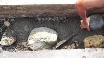 Construction, Worker Hands smooth wet cement in wooden frame at a construction site during daytime to ensure an even surface video