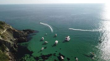 Aerial panoramic view of seascape with crystal clear azure sea and rocky shores. Yachts in a beautiful lagoon on backdrop of rocks. The concept of an ideal destination for summer travel and vacation. video