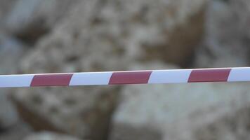 Red and white warning tape swinging in the wind. Protection sign. Don't cross the line. Red White caution tape pole fencing is protects for No entry. Backdrop without people, empty street. video