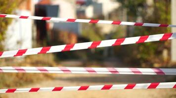 Red and white warning tape swinging in the wind. Protection sign. Don't cross the line. Red White caution tape pole fencing is protects for No entry. Backdrop without people, empty street. video