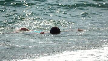 flicka hav Vinka. tonåringar flicka i blå baddräkt och vatten glasögon spelar med vågor på de strand, Strand. Semester sommar rekreation på hav begrepp. video