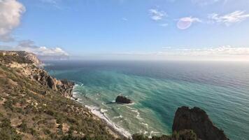 espaço de tempo fofo cirro nuvens comovente dentro azul céu sobre tormentoso mar com rochoso costa. abstrato aéreo natureza verão oceano pôr do sol, mar e céu visualizar. clima e clima mudança video