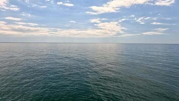 Sea water surface. Aerial view on calm water surface, camera flies over clear sea ocean. Sun glare. Abstract nautical summer ocean nature. Holiday and travel. Weather and climate change. Slow motion video