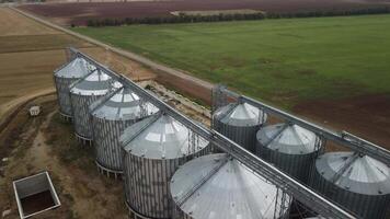 Grain elevator. Metal grain elevator in agricultural zone. Agriculture storage for harvest. Grain elevators on green nature background. Exterior of agricultural factory. Nobody. video