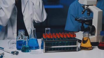 Young scientists conducting research investigations in a medical laboratory, a researcher in the foreground is using a microscope video