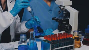 Young scientists conducting research investigations in a medical laboratory, a researcher in the foreground is using a microscope video