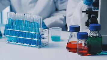 Young scientists conducting research investigations in a medical laboratory, a researcher in the foreground is using a microscope video