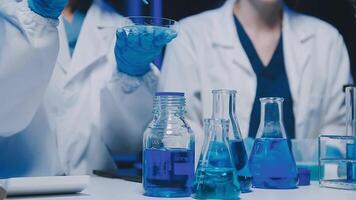 Young scientists conducting research investigations in a medical laboratory, a researcher in the foreground is using a microscope video