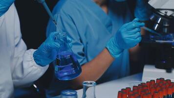 Young scientists conducting research investigations in a medical laboratory, a researcher in the foreground is using a microscope video