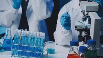 Young scientists conducting research investigations in a medical laboratory, a researcher in the foreground is using a microscope video