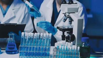 Young scientists conducting research investigations in a medical laboratory, a researcher in the foreground is using a microscope video