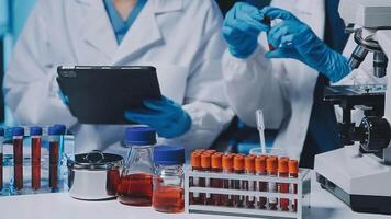 Young scientists conducting research investigations in a medical laboratory, a researcher in the foreground is using a microscope video